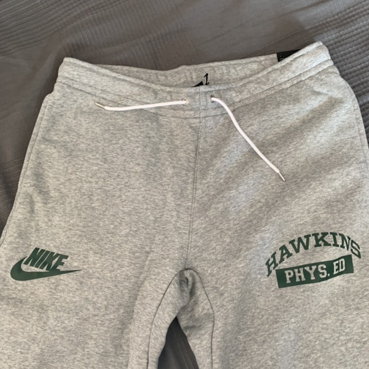  [나이키] 나이키 X 기묘한이야기 팬츠(Nike X Stranger Things Hawkins Phys Ed Fleece Pants, CQ3656-063)