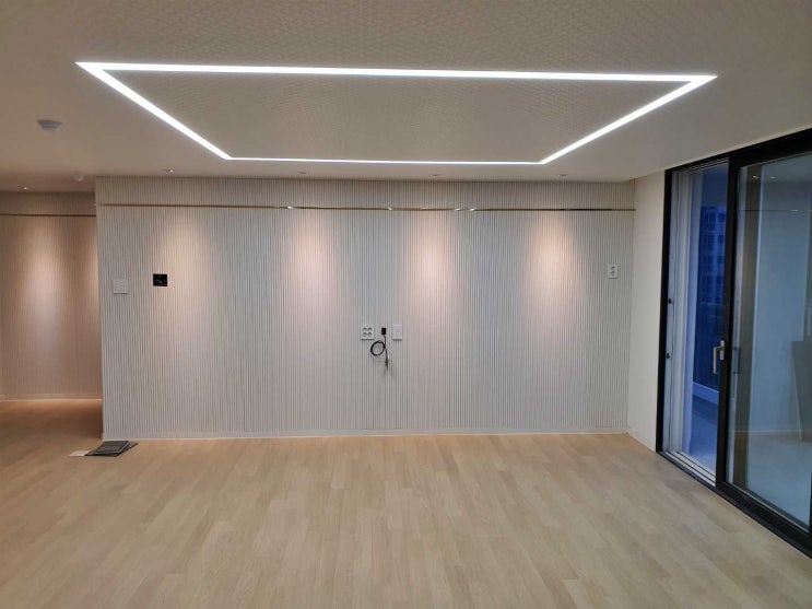  템바보드 아트월과 모던한 라운드 거실의 매립형 직사각 라인조명