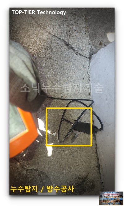 비산동 주택 마당 시멘트 바닥에 청음기 센서를 올려놓고 누수음을 듣는 모습