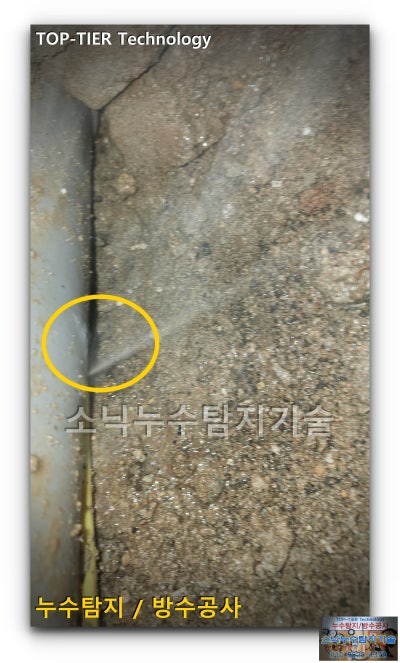 굴착한 흙 속에서 드러난 배관과 노란 원으로 표시한 누수 지점