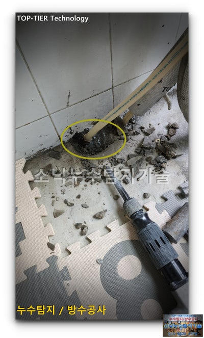 봉무동 상가 화장실 바닥을 부분만 걷어내 매립 배관이 드러난 모습, 의심 지점이 노란 원으로 표시되어 있다
