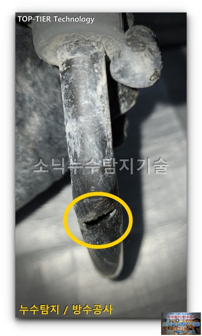잘라낸 PB 급수배관 표면에 세로로 갈라진 크랙을 노란 원으로 표시한 모습