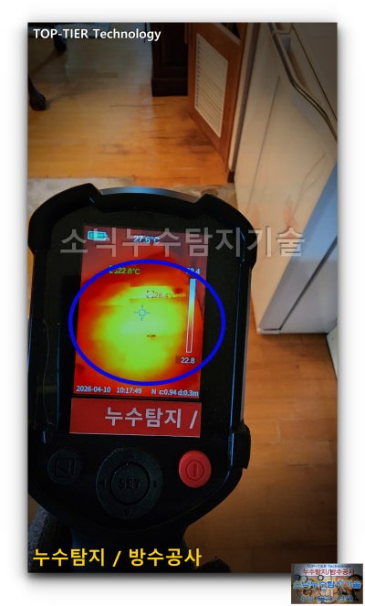 손에 든 온도 차 확인 카메라 화면에 붉고 노란 온도 분포가 넓게 번져 나타나고 파란 원으로 특이 구간이 표시된 수성구 아파트 온수배관 탐지 장면