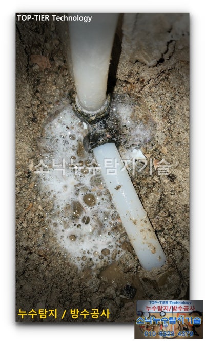 흰색 배관 이음 부위에 비눗물을 뿌리자 흰 거품이 부풀어 오르며 물이 새는 자리가 드러난 장면
