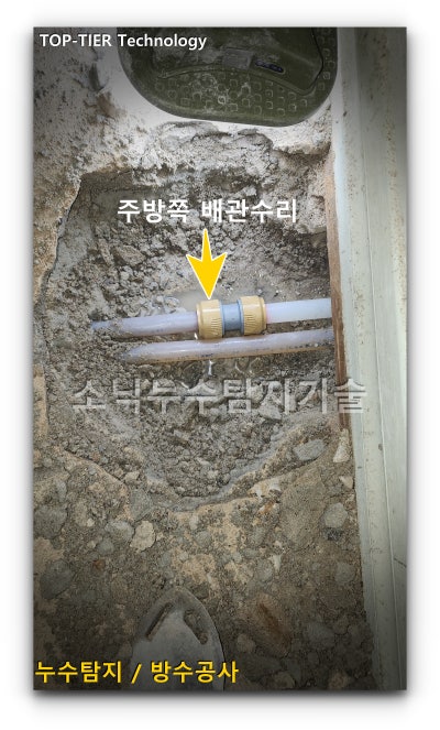 주방 바닥 굴착 자리에서 흰색 XL 배관을 잘라내고 연결 부속으로 이어 수리를 마친 상태
