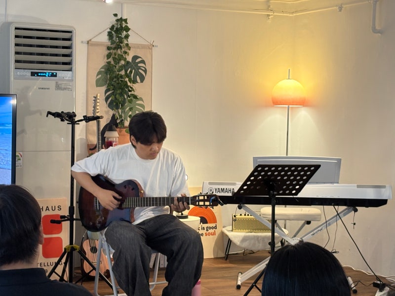 오늘은뮤직 의왕점 오플리 무대에서 장시영 강사가 나일론 기타를 연주하는 모습