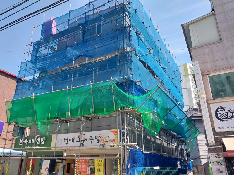 좁은 골목의 현장 여건과 보행자 안전을 고려해 설치한 강관비계와 안전망