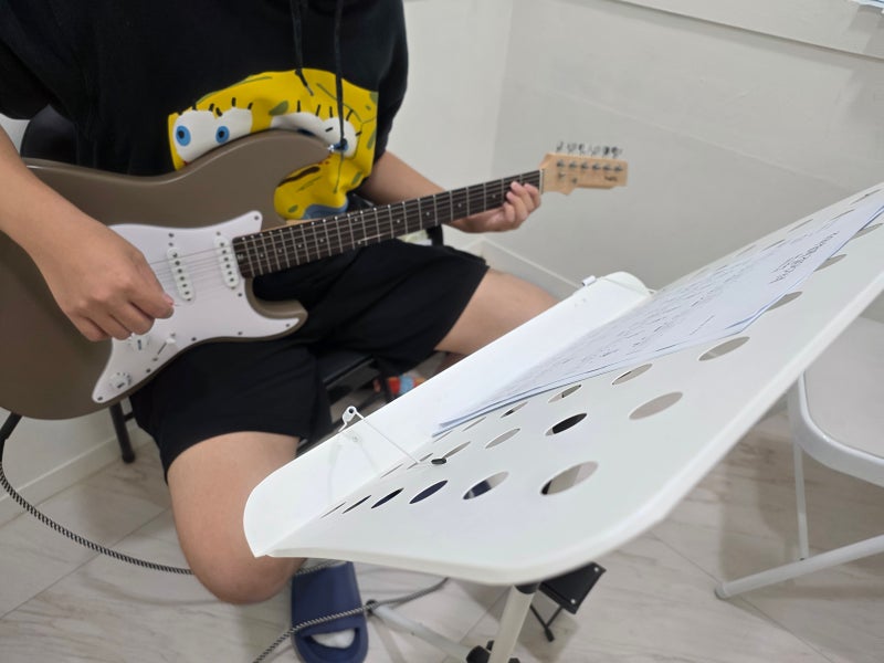 오늘은뮤직 김해점 기타 레슨에서 강사가 코드 잡는 손 모양을 짚어 주는 모습