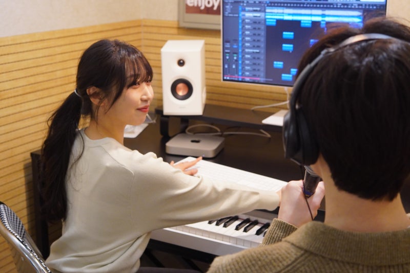 오늘은뮤직 안산점 미디 작곡 1:1 레슨, 강사가 마스터 건반 앞에서 헤드폰을 쓴 수강생에게 모니터 속 작업 화면을 설명하는 모습