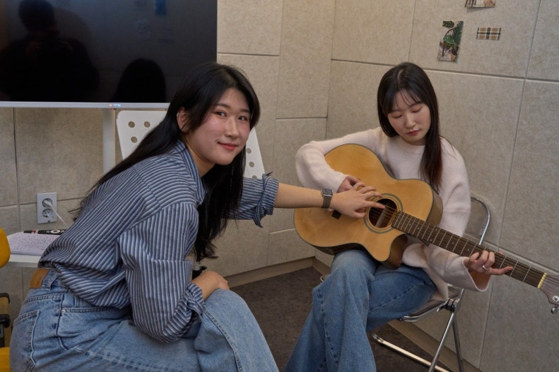 오늘은뮤직 광주점 기타 1:1 레슨실, 강사와 수강생이 마주 앉아 기타를 잡은 모습