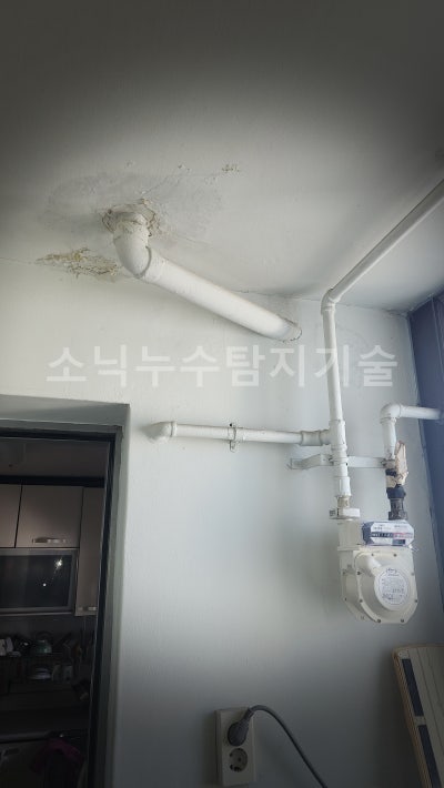 아래층 세탁실 베란다 천장에 드러난 배수배관과 그 주변으로 번져 페인트가 들뜬 자국