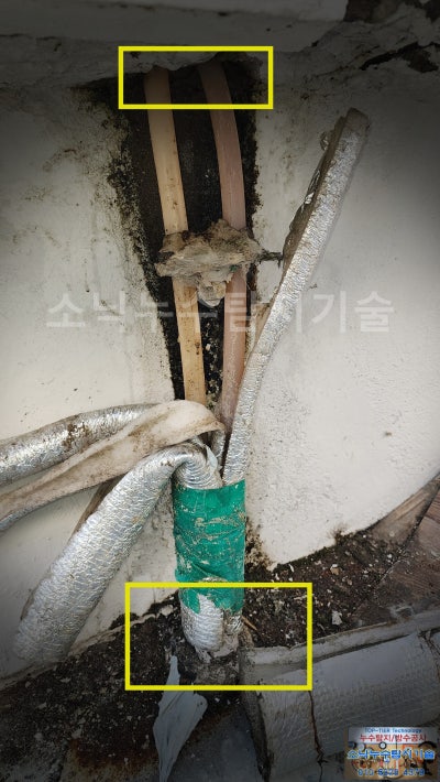 2층 확장 지붕 아래로 지나가는 배관과 그 주변에 물이 스며 나온 젖은 자국을 표시한 사진