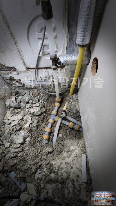 굴착한 베란다 바닥에서 문제 구간을 잘라내고 흰색 XL 배관으로 다시 연결한 수리 완료 모습