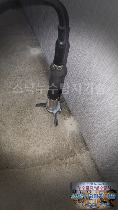 달성군 가창면 주택 방 바닥과 벽이 만나는 모서리에 청음 탐지 센서를 대고 누수음을 듣는 모습