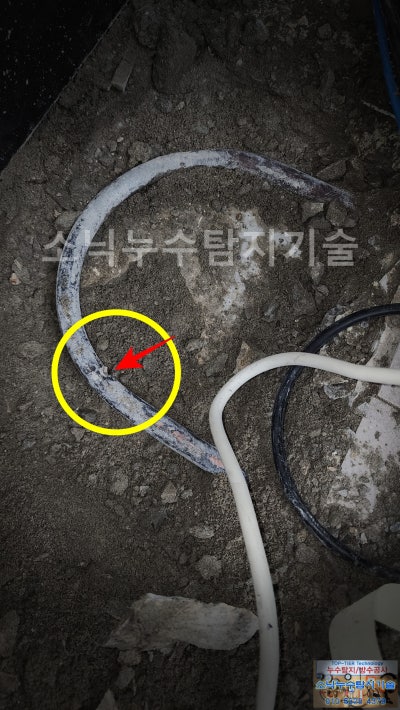 바닥을 굴착해 드러난 난방 동관, 노란 원으로 표시한 관 측면에 피스가 스친 자국이 보인다