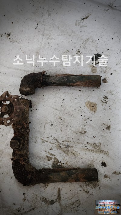 잘라낸 난방 게이트밸브와 양쪽 강관, 표면이 붉게 삭아 있는 부식 상태