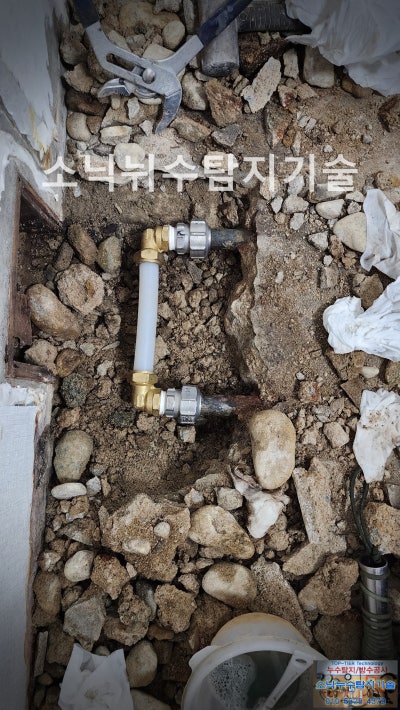 굴착한 바닥에서 부식된 강관을 잘라내고 흰색 XL 배관과 부속으로 이어 놓은 수리 부위